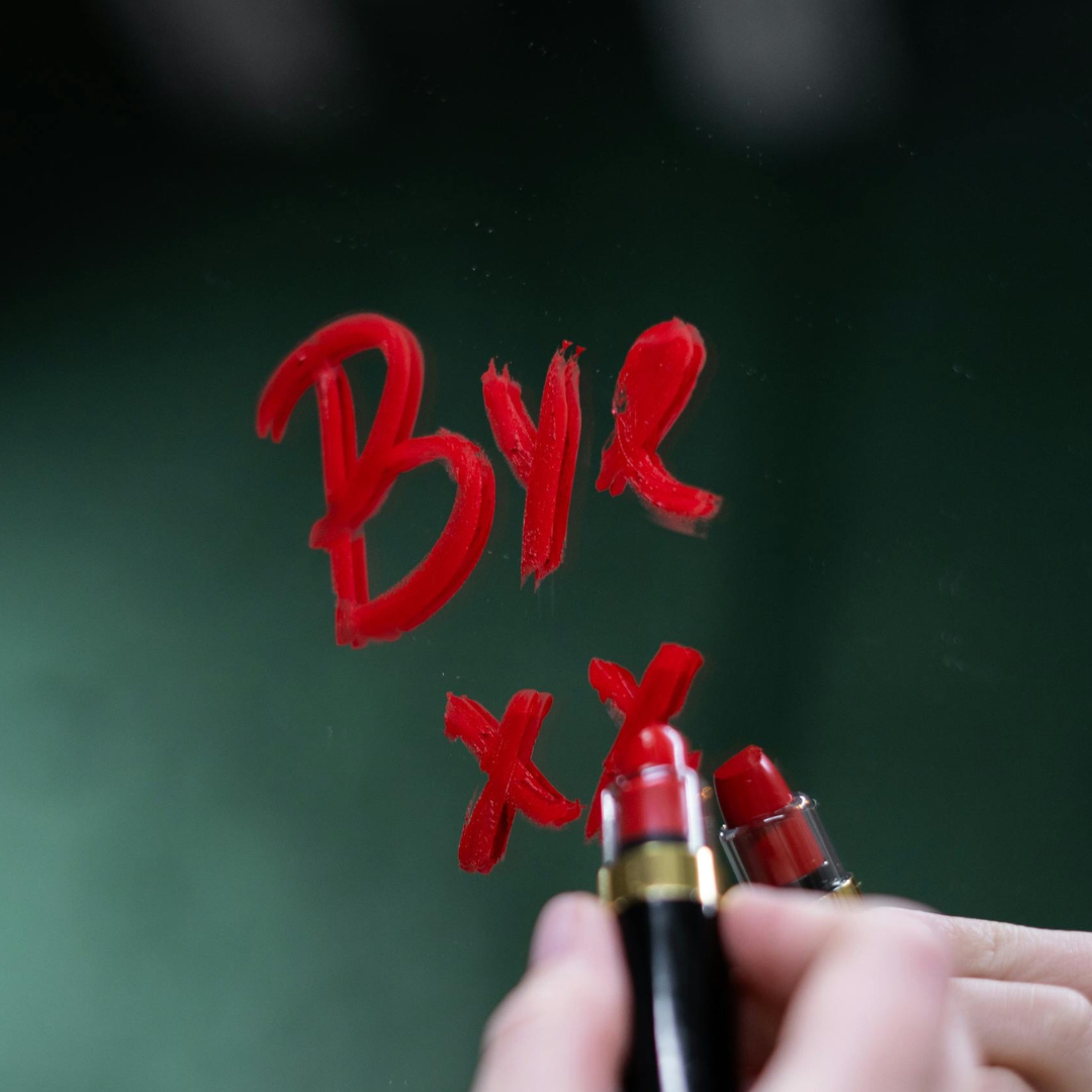 'bye xx' written in lipstick on a mirror
